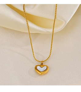 Close-up of golden heart pendant necklace with white mother-of-pearl inlay on beige silk
