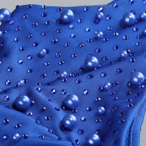 Close-up of dark blue fabric featuring tonal pearls and faceted rhinestones for evening dress