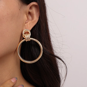 Fashionable large gold geometric hoop earring worn by a model for a minimalist style