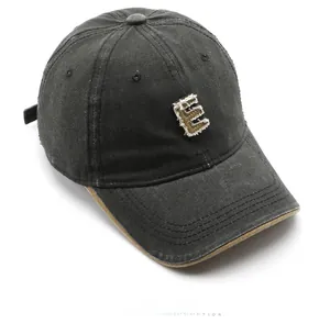 Close-up of vintage embroidery and distressed fabric on charcoal grey baseball cap