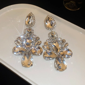 Detailed close-up of pear-shaped rhinestone chandelier earrings with sparkling silver plating