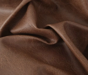 Macro-opname van bruin kunstleer met vintage olie-wasafwerking en zachte korrelstructuur