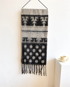Detail of soft cashmere-like scarf with black and white polka dots and long fringes