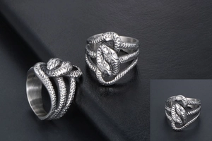 Macro detail of silver double-headed snake ring featuring intricate scale textures