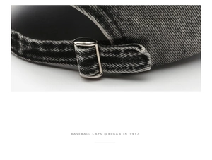 Detail of adjustable silver metal buckle and grey washed denim texture on baseball cap