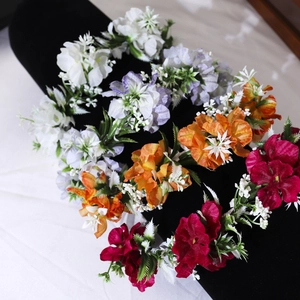 Detail of colorful floral headbands with fabric flowers on a black velvet stand