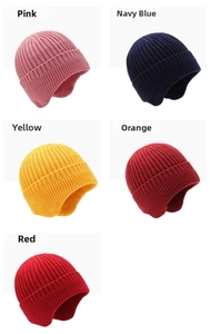 Dettaglio dei cappelli in maglia con paraorecchie nei colori rosa, blu, giallo e rosso