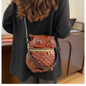 Detailed view of creative owl-shaped crossbody bag featuring textured brown leather scale patterns