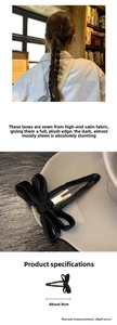Detail shot of black satin bow hair clip measuring 8cm with handmade metallic base