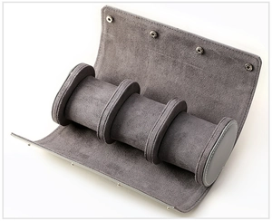 Detailed view of grey velvet lining and three watch pillows in a travel storage roll
