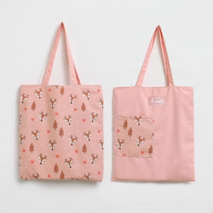 Detail of pink canvas tote bags featuring forest animal prints and durable handle straps