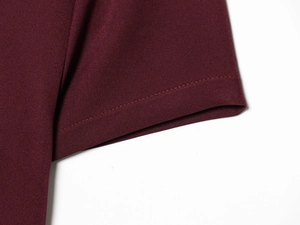 Detailed close-up of dark burgundy dress sleeve showing professional double-needle stitching