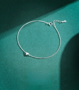 Macro shot of S925 sterling silver minimalist heart pendant bracelet with logo tag