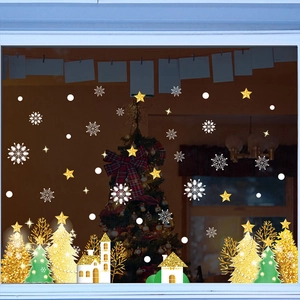 Detail of Christmas window decals featuring gold trees, white houses, and snowflakes
