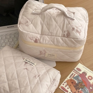 Close-up of quilted makeup bag with dog prints and square handle storage pouch