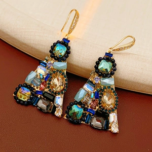 Detailed close-up of vintage gold triangle earrings with multi-colored gemstones