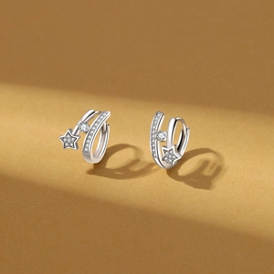 Close-up of silver hoop earrings with star charms and sparkling zircon pavé detail