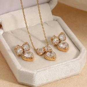 Golden bow heart jewelry set with clear zircons in a velvet gift box display