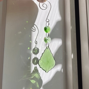 Macro detail of 50mm green crystal suncatcher showing leaf pendants and light reflections