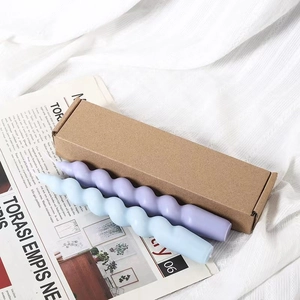 Detail of spiral twisted candles in purple and light blue on white fabric and magazine