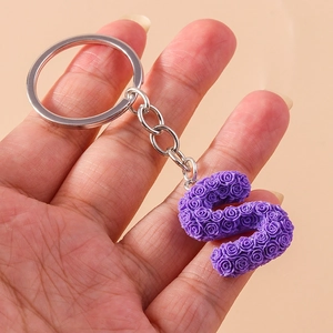 Close-up of letter S keychain featuring detailed purple resin rose floral texture