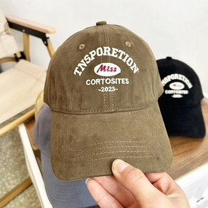Close-up of vintage brown baseball cap featuring detailed retro embroidery and 2023 lettering