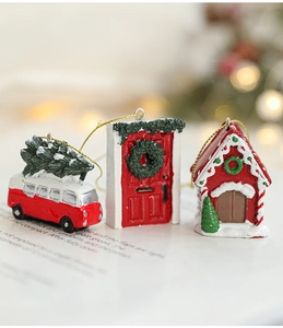 Miniature resin Christmas trio featuring a red bus, festive door, and gingerbread house