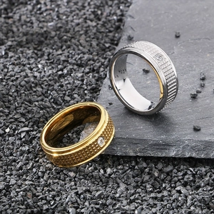 Detail of gold and silver stainless steel rings with checkered pattern and zircon inlay