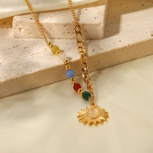 Primer plano de collar de titanio dorado con cuentas de colores y colgante de sol en seda
