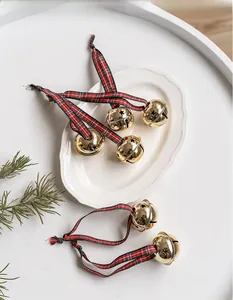 Detail showing six gold Christmas bells with star cutouts and red-green plaid ribbons