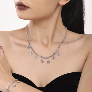 Detail of silver spiral pendant necklace and matching bracelet on model with clean background