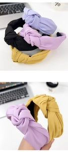Detail of wide knotted fabric headbands in assorted colors like yellow and purple