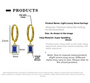 Detail showing 23mm length dimensions of gold titanium steel earrings with blue zircon