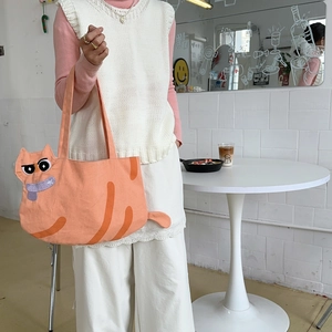 Detail of cute orange cat-shaped canvas tote bag with 3D ears and cartoon embroidery