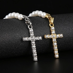 Détail macro de colliers cubains or et argent avec croix en cristal et perles