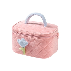Pink corduroy makeup bag with quilted pattern, blue handle and cute floral detail