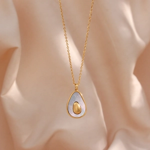 Detail view of avocado necklace pendant with iridescent white shell on gold chain