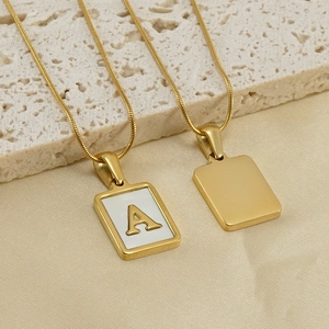 Détail d'une chaîne serpent dorée avec pendentif lettre A en nacre rectangulaire