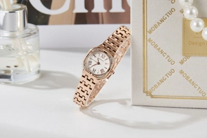Detail view of rose gold square watch dial with crystals and Roman numerals