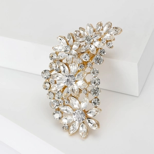 Detail shot of vintage flower brooch with golden base and sparkling clear rhinestones