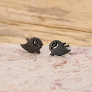 Macro shot of black cartoon ghost stud earrings on natural pink stone background