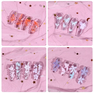 Detail showing 3D floral nail art charms with lily patterns on long coffin tips