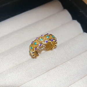 Detailed close-up of 18k gold plated vintage open ring with purple and green enamel accents