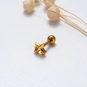 Detail of a gold star-shaped stud earring with a centered clear zircon and screw back
