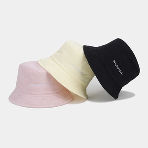 Close-up of mama embroidery on textured terry bucket hats in pink, yellow and black