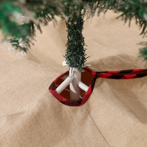 Close-up of linen Christmas tree skirt with red buffalo plaid edges and ribbon ties