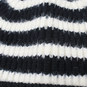 Close-up of thick striped knit texture with soft rabbit fur fibers on winter beanie