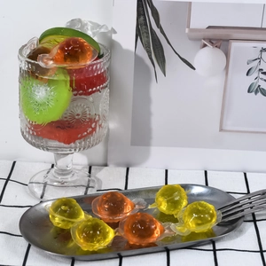 Cubetti di ghiaccio a forma di pianeta in vari colori con dettagli ad anello e frutta