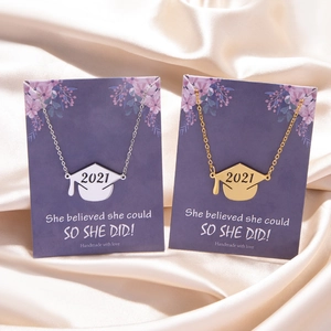 Detail of graduation necklaces with 2021 mortarboard charms on floral gift cards