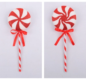 Detail of red and white spiral Christmas lollipop ornaments with glitter and silk bows